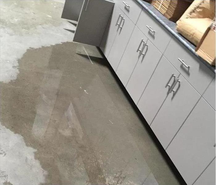 Water flooded on the grey flooring of a warehouse of a business 