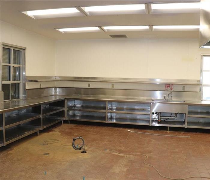 Water extracted from floors and wet drywall removed in school kitchen.