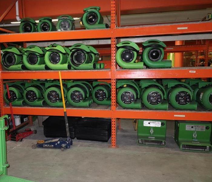 Green equipment stacked in a warehouse.